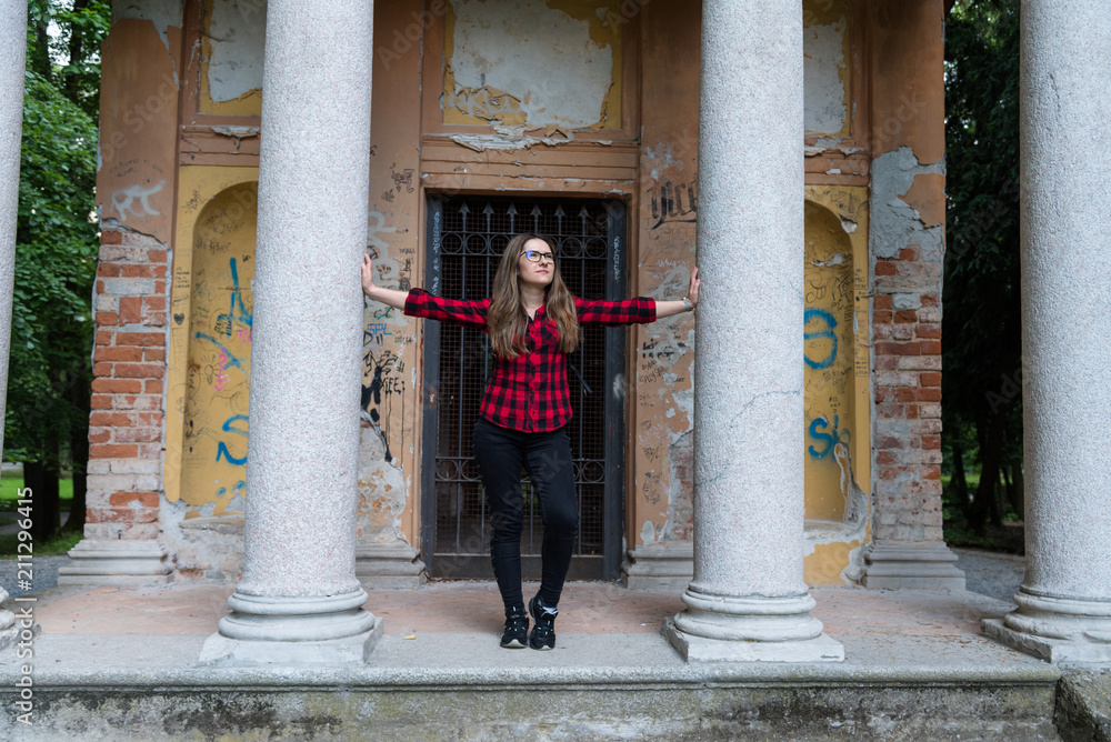The young girl posing in the park in an abandoned building