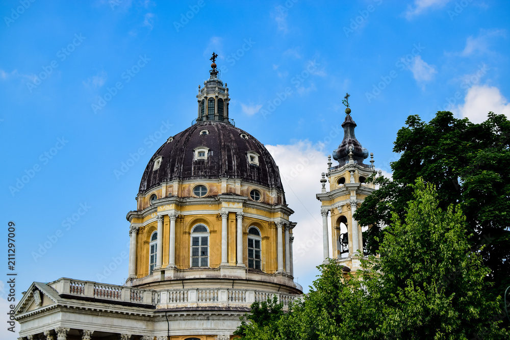 Detail of the dome of the Basilica of Superga next to one of its towers that hides a bell with its beautiful yellow facade. Photograph taken in Turin, Italy.