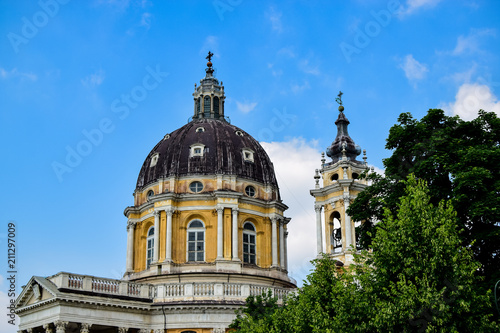 Detail of the dome of the Basilica of Superga next to one of its towers that hides a bell with its beautiful yellow facade. Photograph taken in Turin, Italy.