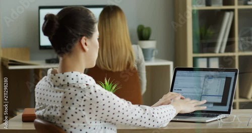 Rear of the female Caucasian office worker typing and texting on the laptop computer while it being broken and has error writing on the screen. Inside. photo