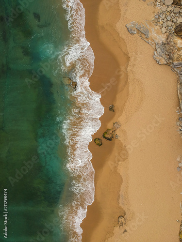 Aerial view of sandy beach with waves. Drone photo 