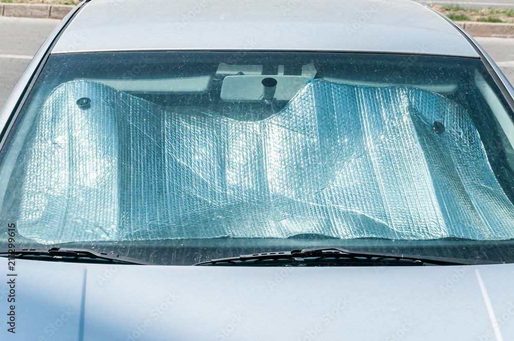 Fototapeta premium Sun reflector on the windscreen or windshield as protection of the car plastic indoor panel from direct sunlight and heat