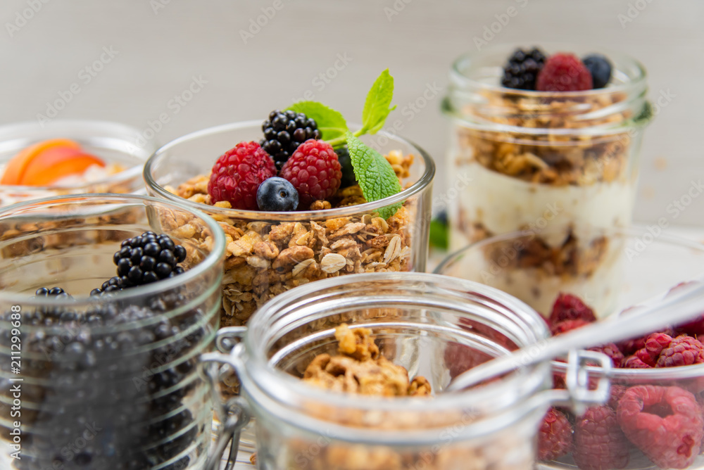 Jars full with granola, yogurt and fresh berries, close-up, selective focus Jars full with granola, yogurt and fresh berries, close-up, selective focus