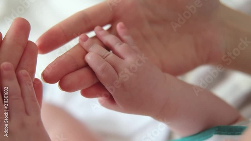 Mother holding baby hand. Newborn baby hand in mother hands. 4K UHD Slow motion