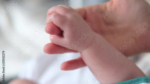 Mother holding baby hand. Newborn baby hand in mother hands. 4K UHD Slow motion