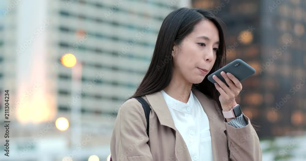 Woman sending audio message on cellphone at outdoor Woman sending audio message on cellphone at outdoor