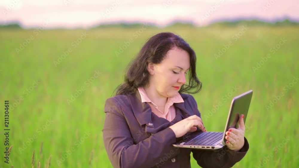 Woman in nature talking video conference on laptop. Camera moves Woman in nature talking video conference on laptop. Camera moves