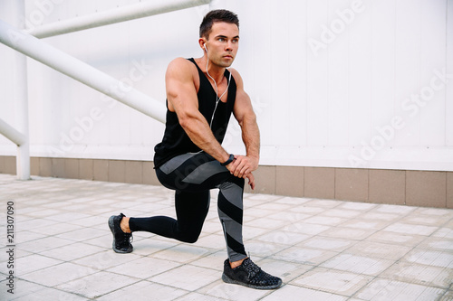 Full length view of thoughtful sportsman doing exercises for body, outdoors