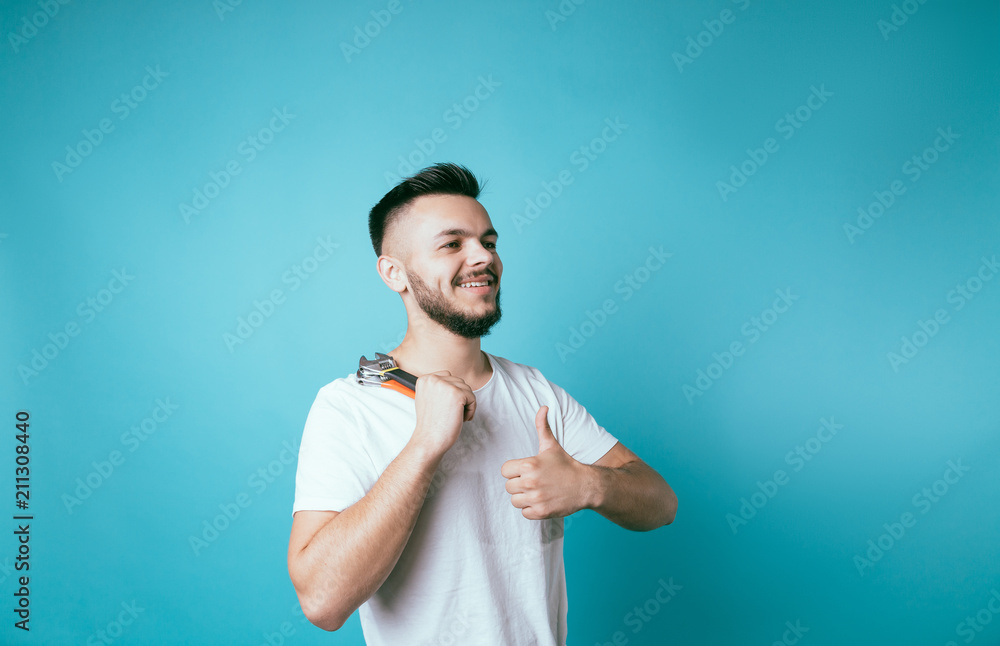 Male portrait with wrench on blue background. bearded smiling guy. builder plumber man. thumbs up boy beard Male portrait with wrench on blue background. bearded smiling guy. builder plumber man. thumbs up boy beard