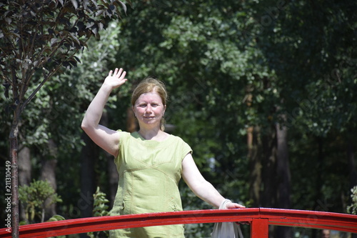 кавказская женщина жестикулирует одной рукой,прогулка летом в парке  
