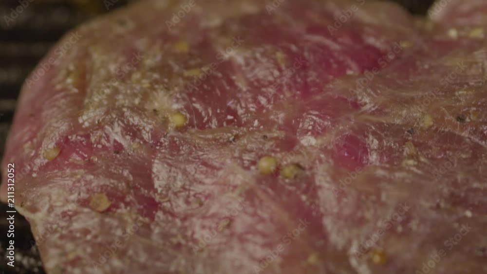 Close-up - A Fresh Pork Steak Grated With Aromatic Spices Is Fried In A Grill Pan. Restaurant Cuisine Close-up - A Fresh Pork Steak Grated With Aromatic Spices Is Fried In A Grill Pan. Restaurant Cuisine