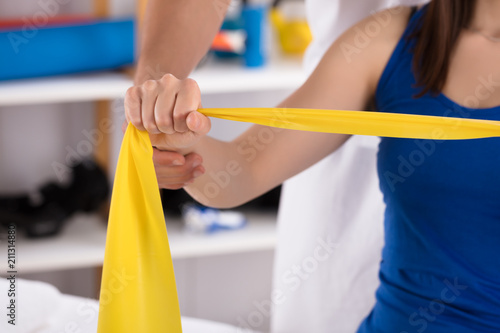 Physiotherapist Assisting Woman While Doing Exercise