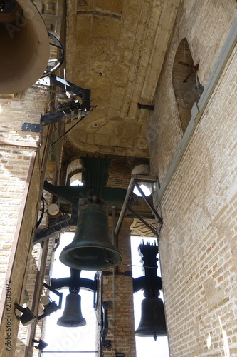 Ancient bells of different sizes. Bells of metal with rust and stains. Church courtyard with a bell tower. Rusted bells. Exposition in the open-air museum.