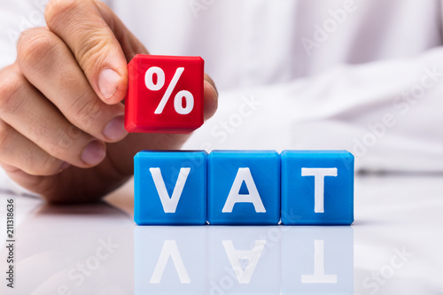 Person Placing Red Percentage Block Over Vat photo