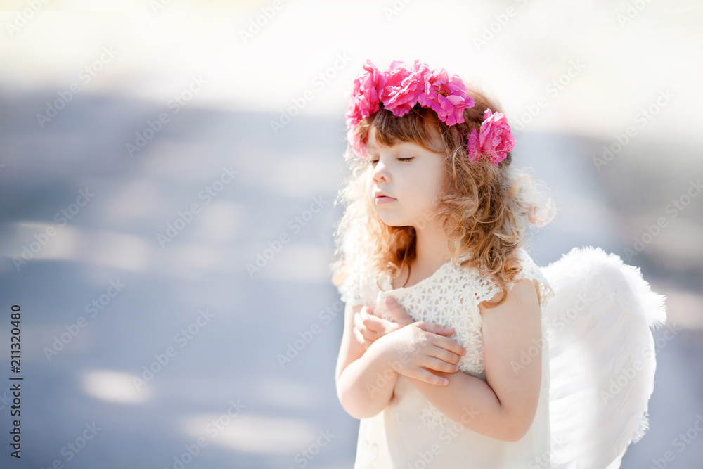 Portrait of beautiful little Angel girl with floral wreath Portrait of beautiful little Angel girl with floral wreath