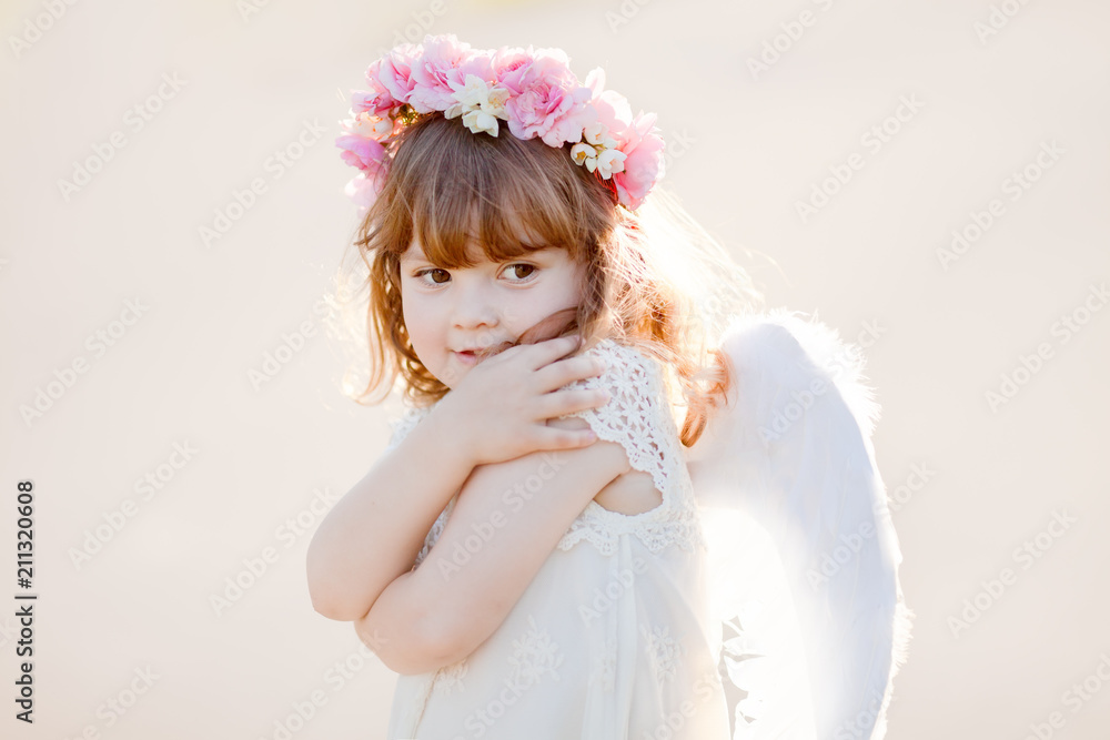 Portrait of beautiful little Angel girl with floral wreath Portrait of beautiful little Angel girl with floral wreath