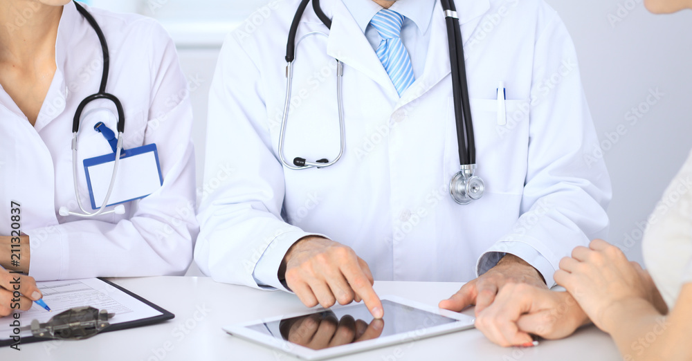 Doctor and patient talking while sitting at the table . Concept of support and trust in medicine Doctor and patient talking while sitting at the table . Concept of support and trust in medicine
