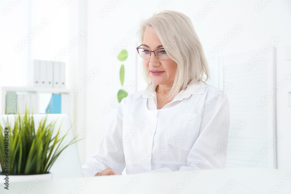 Senior female receptionist working in hospital Senior female receptionist working in hospital