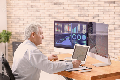 Male broker working in offi...