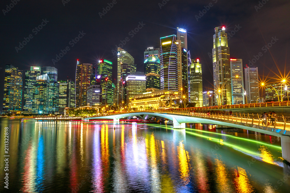 Naklejka premium Singapur budynki finansowe i drapacze chmur w centrum miasta odzwierciedlone w morzu portu. Singapur nocą. Nocna scena nabrzeża marina bay.