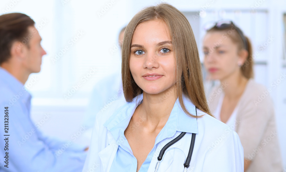 Happy doctor woman with medical staff at the background in hospital office Happy doctor woman with medical staff at the background in hospital office