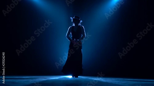 Girl dances flamenco. Blue background. Silhouette