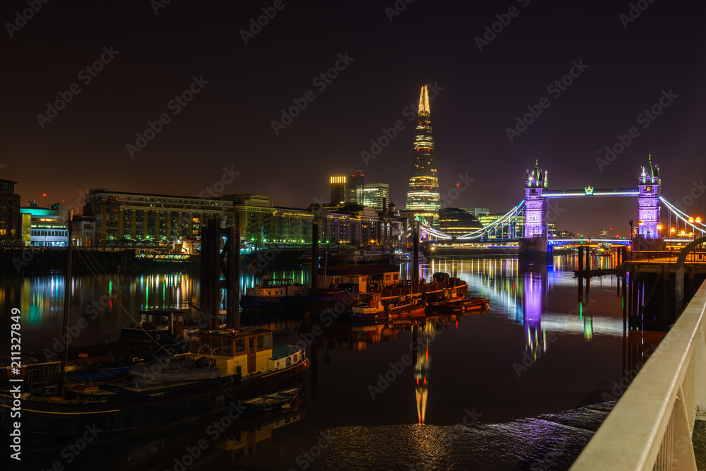 Famous Tower Bridge at night with light reflections, London, England