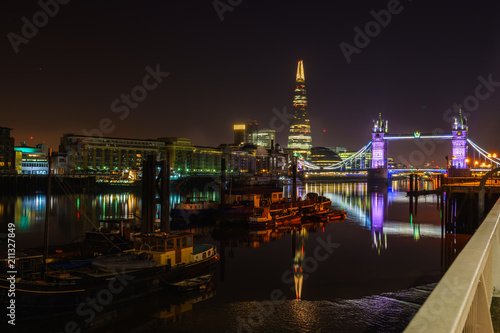 Famous Tower Bridge at night with light reflections, London, England