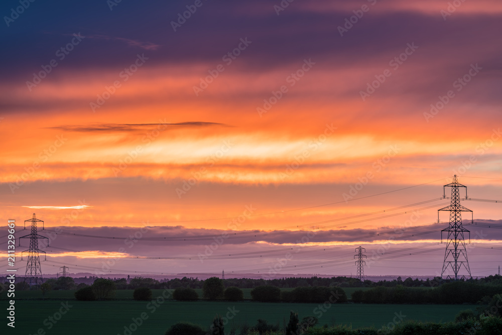 Electric transmission towers at colorful sunset Electric transmission towers at colorful sunset