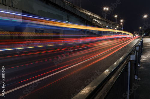 Time-lapse Photograph of Light Trails caused by cars driving along a road in the city.