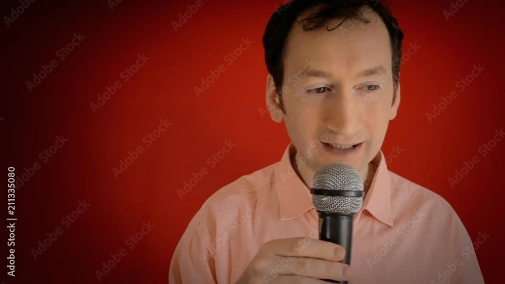 A funny ugly man speaking to an audience, waiting for the crowd to react, and then dropping the microphone (the famous mic drop gesture, a display of bold confidence). Close-up shot, red background.
