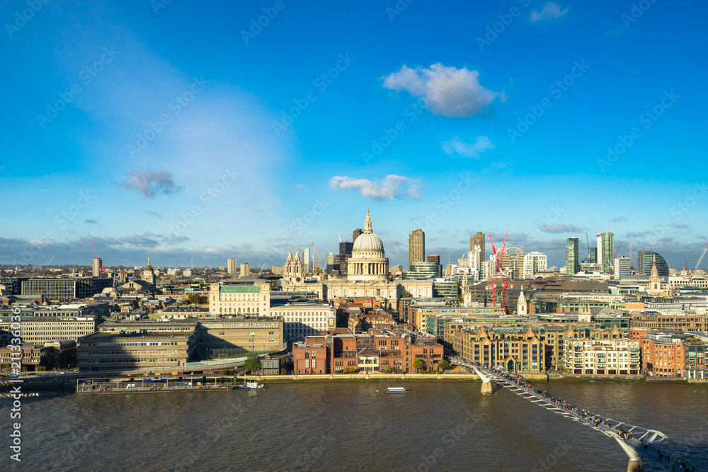 London skyline with a view of St Paul's Cathedral, Millennium Bridge and skyscrapers of the north bank of the River Thames on a sunny day