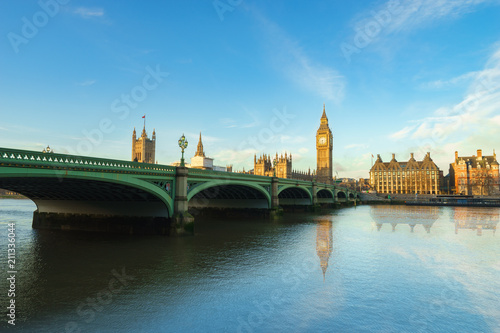 Big Ben and Westminster bridge with blue sky and water reflection in London, United Kingdom