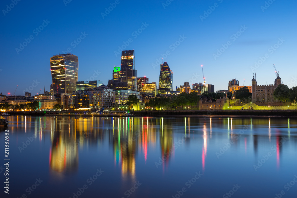 Skyscrapers of London financial district and Tower of London at blue hour 