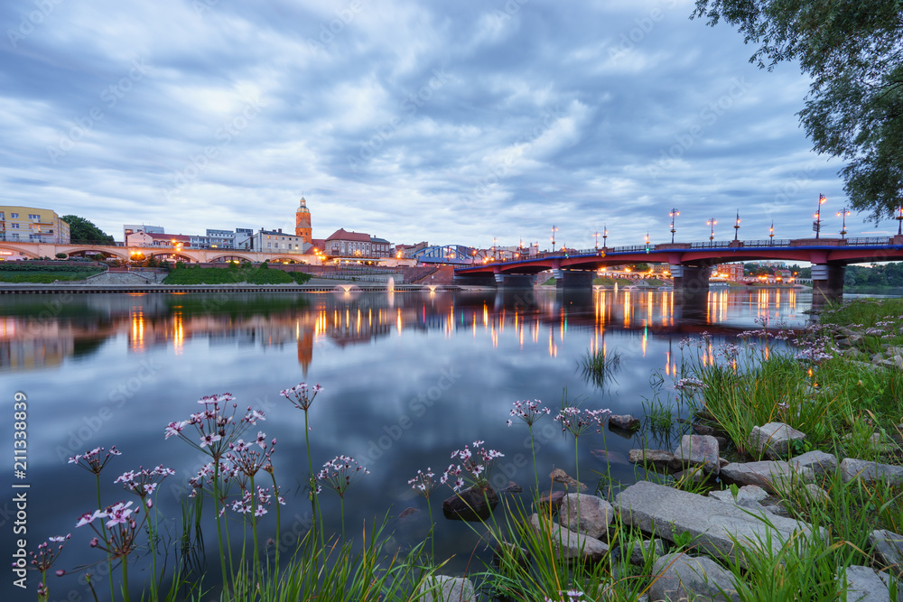 Fototapeta premium Evening skyline of Gorzow city in Poland. Old town bridge and St. Mary's cathedral