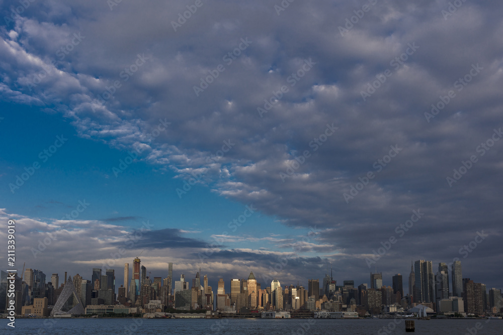 JUNE 6, 2018 - NEW YORK, NEW YORK, USA  - New York City and Hudson River at sunset with ominous clouds over the Manhattan Skyline