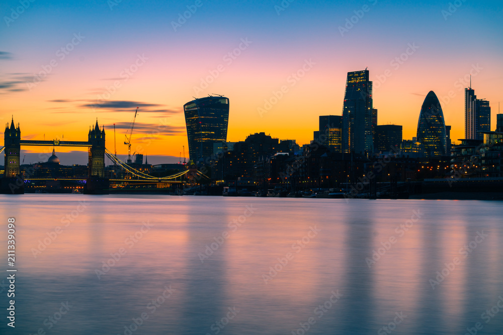 London skyline at dusk including Tower Bridge and skyscrapers at financial district 