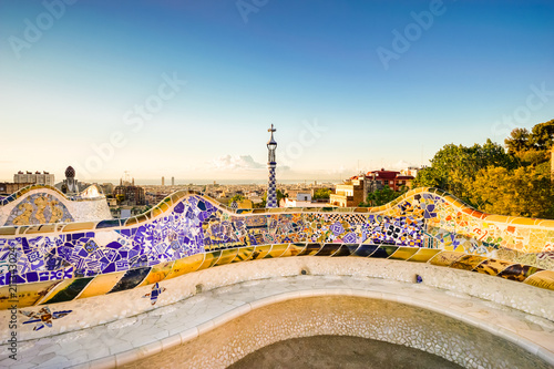 Barcelona at sunrise viewed from summer park Guell. Park was built from 1900 to 1914 and was officially opened as a public park in 1926. In 1984, UNESCO declared the park a World Heritage Site