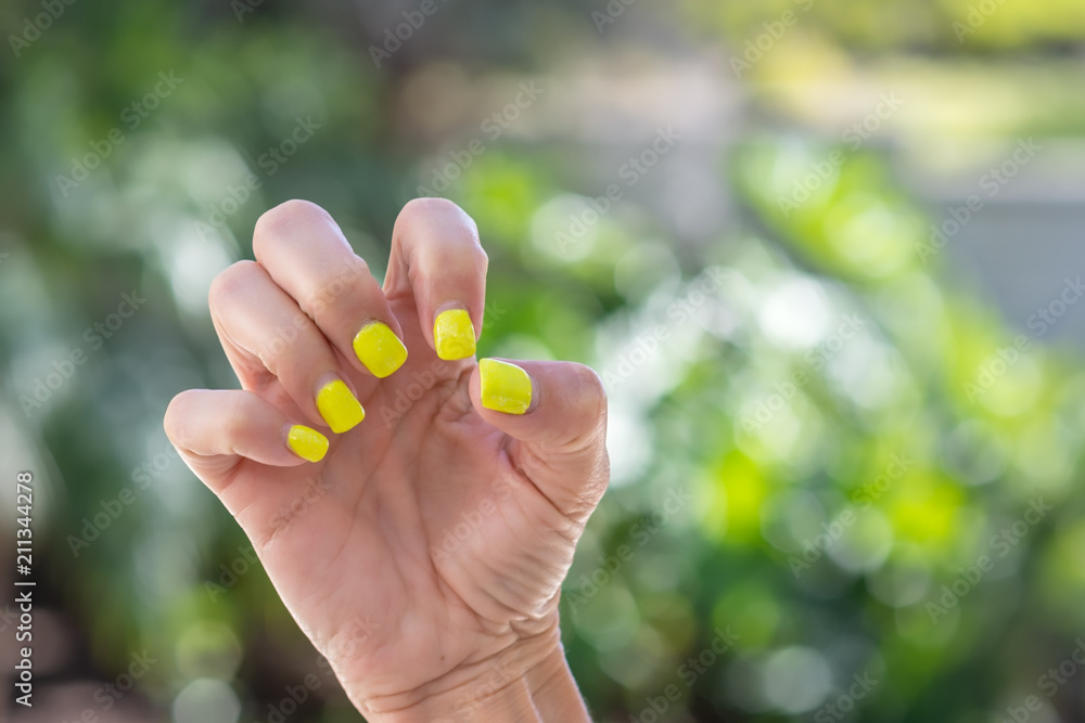 Woman makes a claw with her fingers outdoors in natural light Woman makes a claw with her fingers outdoors in natural light
