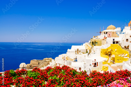 Santorini  Greece. View of traditional cycladic Santorini house with blurry flowers in foreground