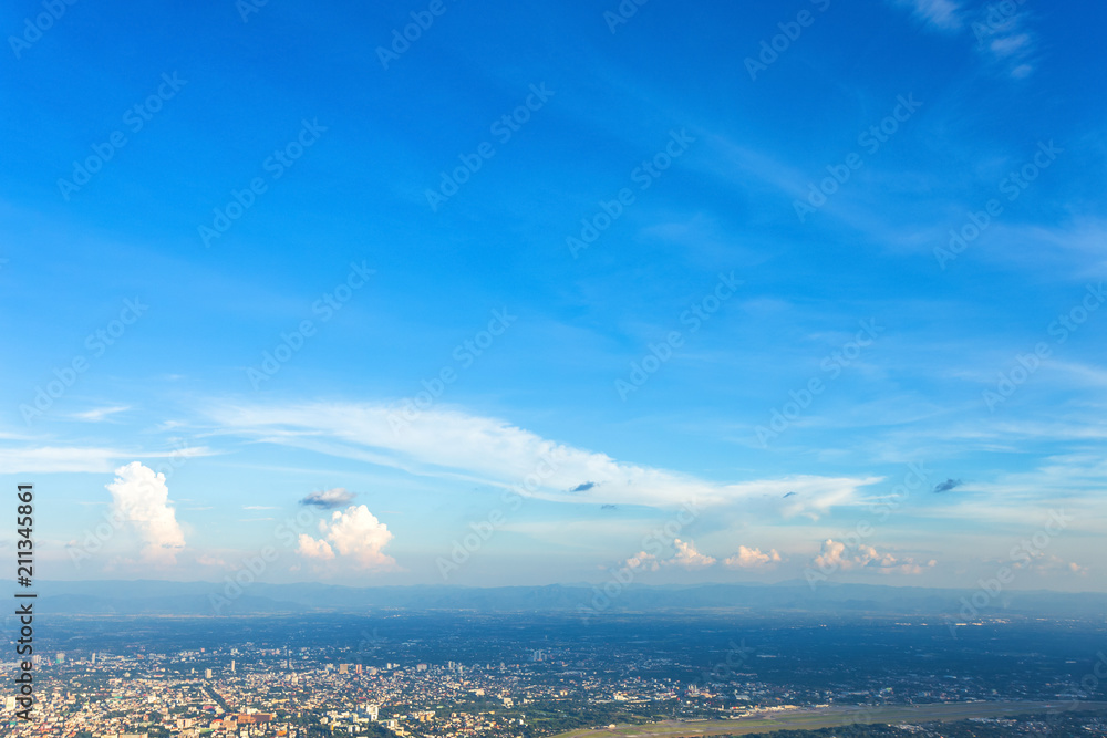 Blue background with white clouds sunset in the sky over city,evening cityscape.
