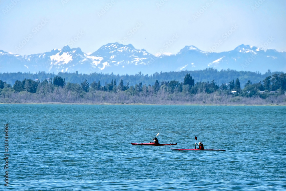 Fototapeta Sea kayaks in water. Kayaking in Pacific Ocean with scenic view of snow capped mountains in Olympic Peninsula. Seattle. Washington State. United States of America.