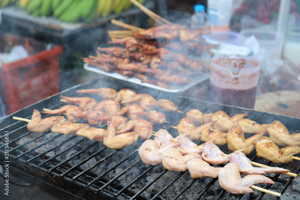 Closeup of grilled chicken on vendor stand, famous street chicken Barbecue in Asia. 