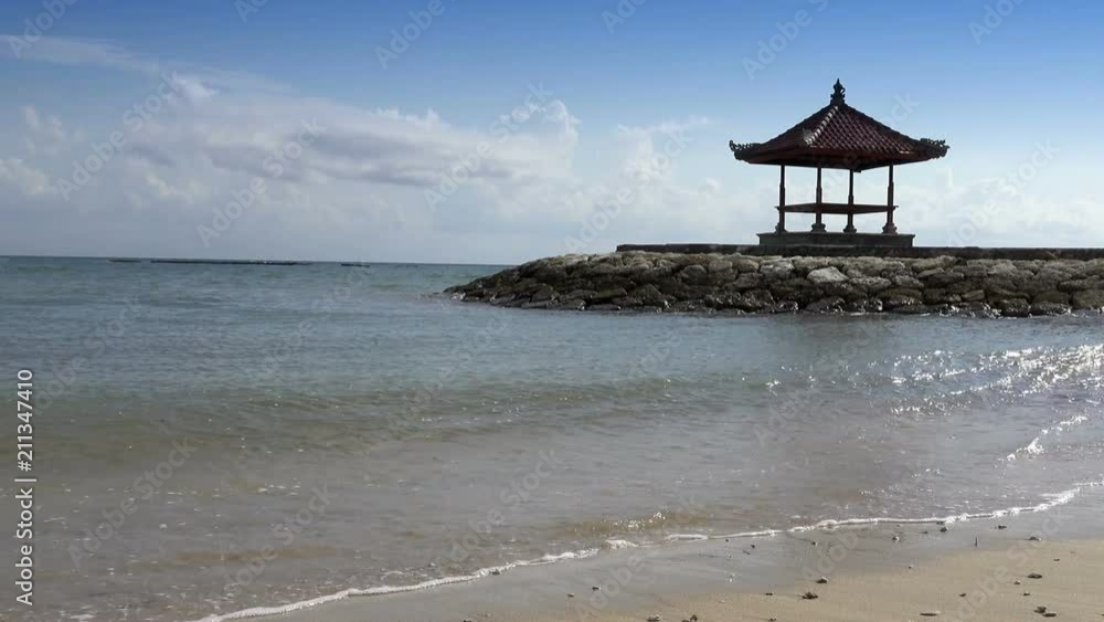Traditional national arbor against the background of the blue sky on the bank of the tropical beach in sunny day. Bali. Indonesia Traditional national arbor against the background of the blue sky on the bank of the tropical beach in sunny day. Bali. Indonesia