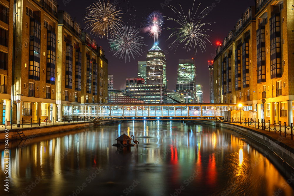 Canary Wharf business district at night with firework, celebration of the New Year in London, UK