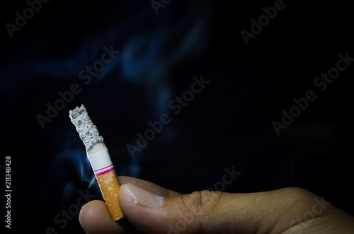 Man hold a cigarette on a dark background