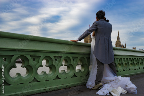 Just married couple standing at Westminster bridge in London, England photo