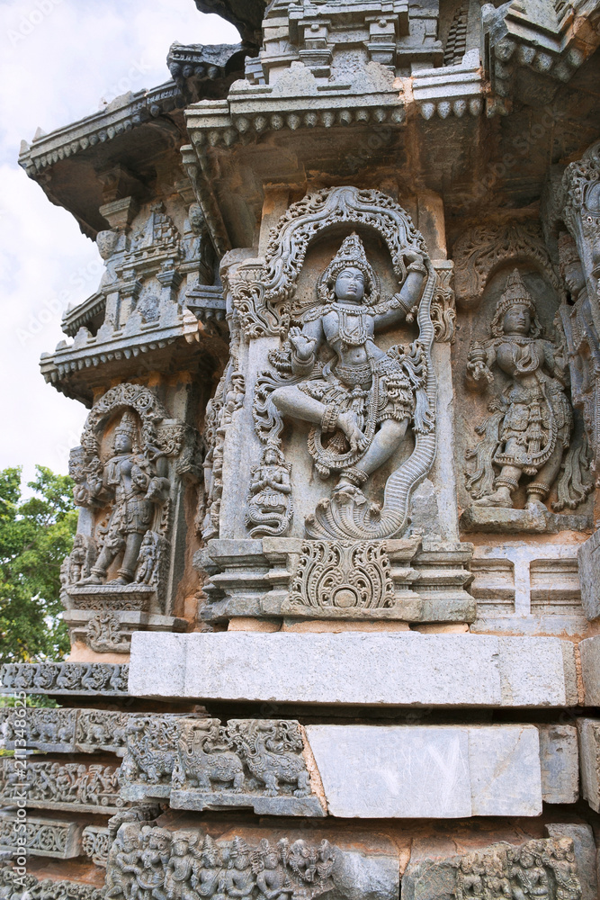 Ornate wall panel reliefs depicting Krishna dancing on the head of serpant Kalia and eventually killing him. Kedareshwara temple, Halebidu, Karnataka