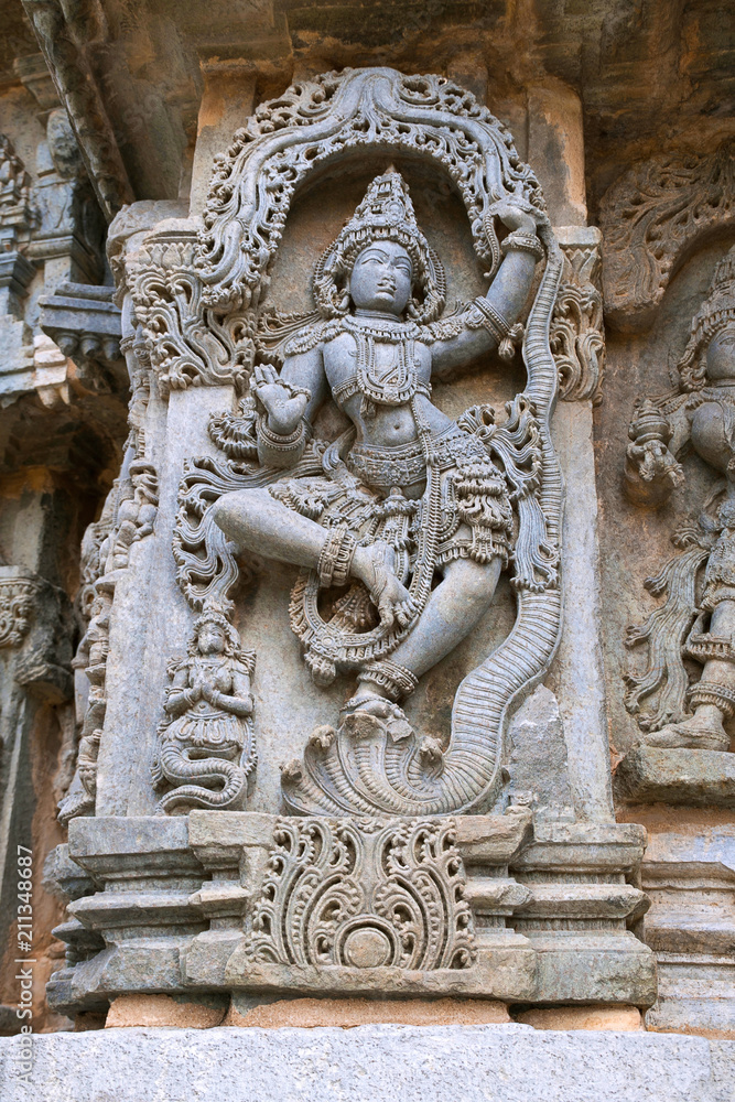 Ornate wall panel reliefs depicting Krishna dancing on the head of serpant Kalia and eventually killing him. Kedareshwara temple, Halebidu, Karnataka