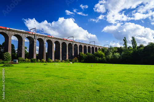 Moving train crossing old railway viaduct in England  photo